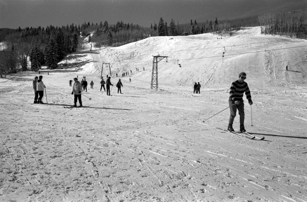 Historical, black and white image of people skiing at Buttermilk.