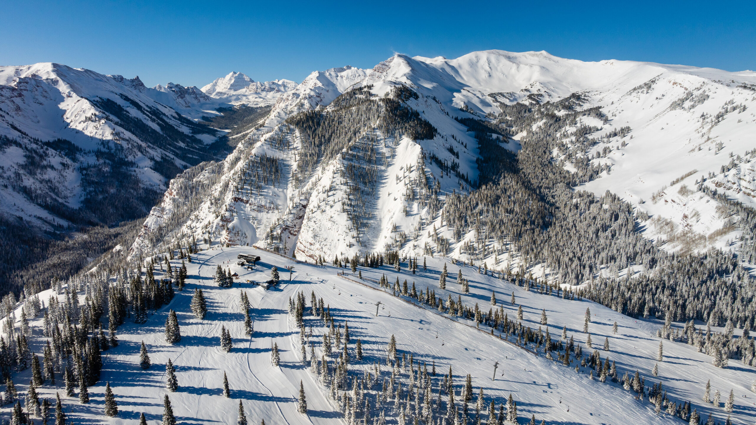 Areal view of Aspen Snowmass, looking at the top of Highlands lift, the bowl, capital peak and the surrounding mountains are covered in snow