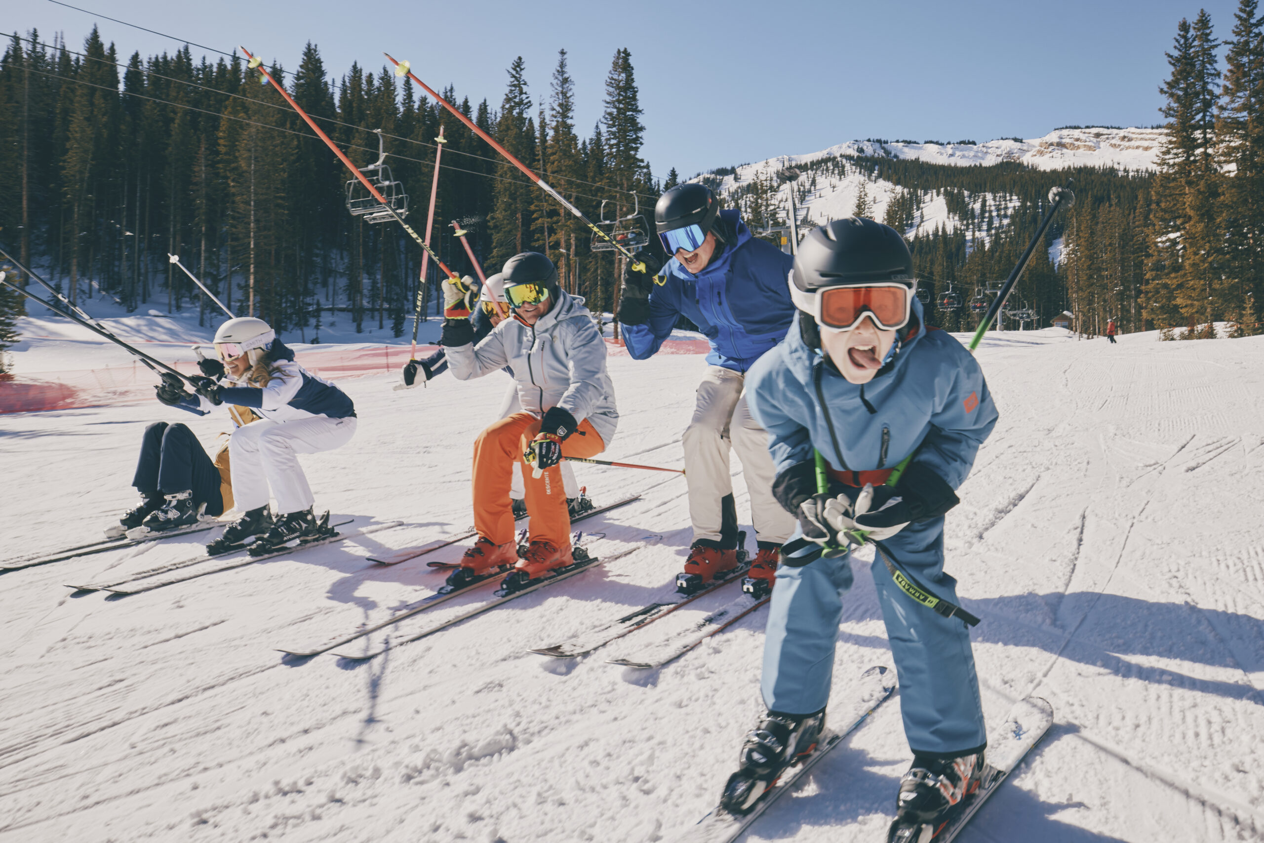 family of skiers on the slopes of snowmass, laughing on a blue bird day on the