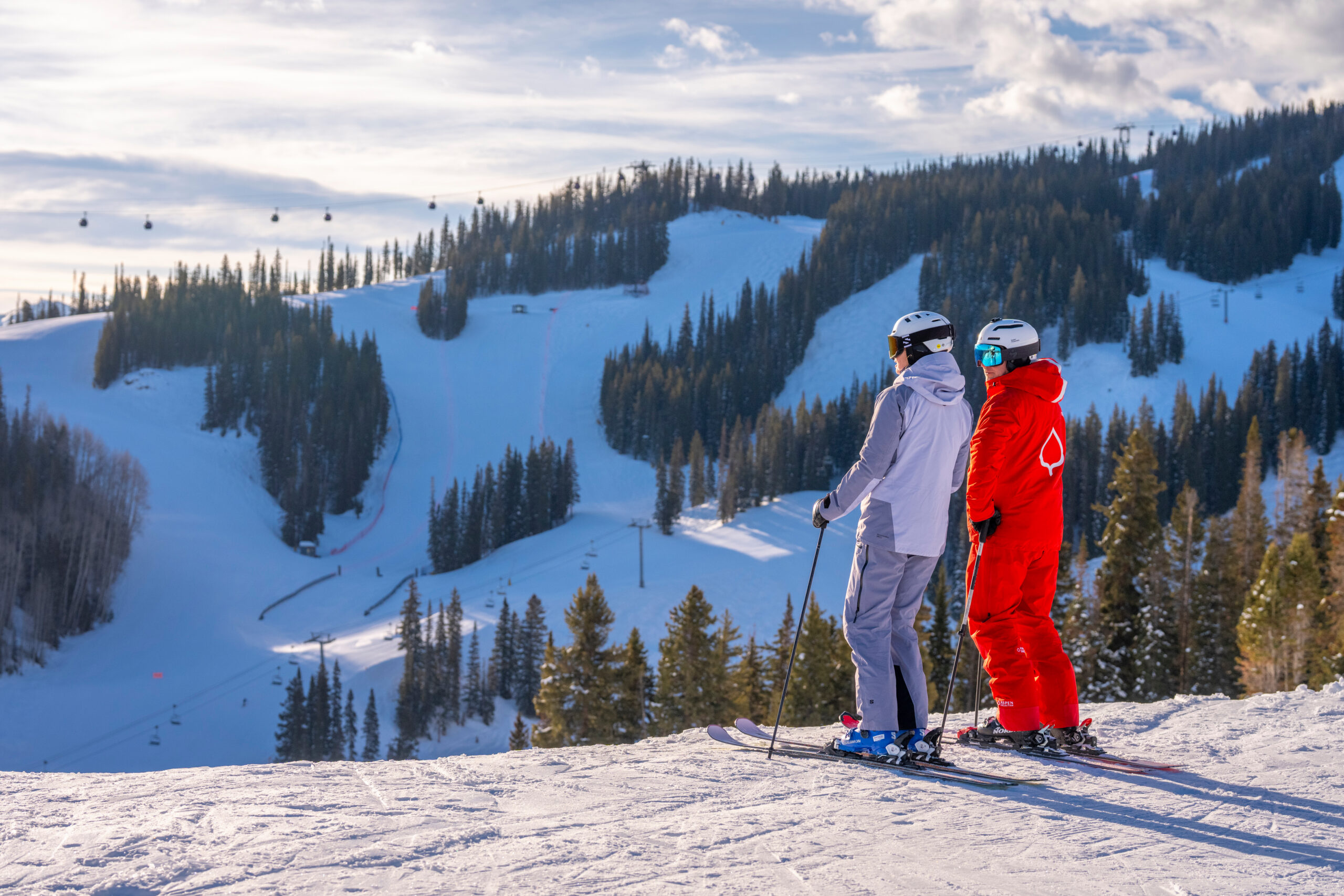 ski pro and student overlook aspen mountain on a sunny morning