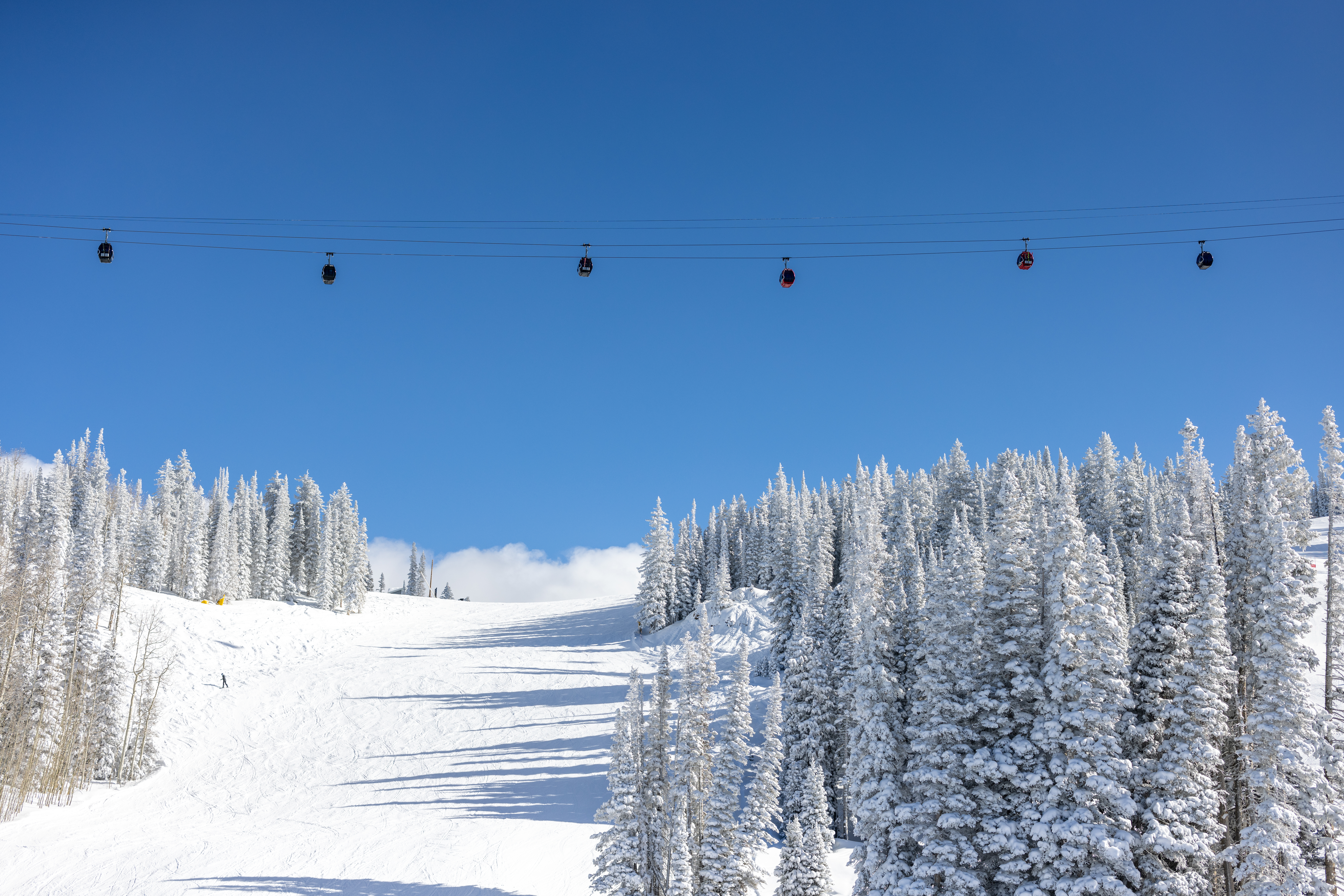 gondola over aspen mountain, white snow and blue skies
